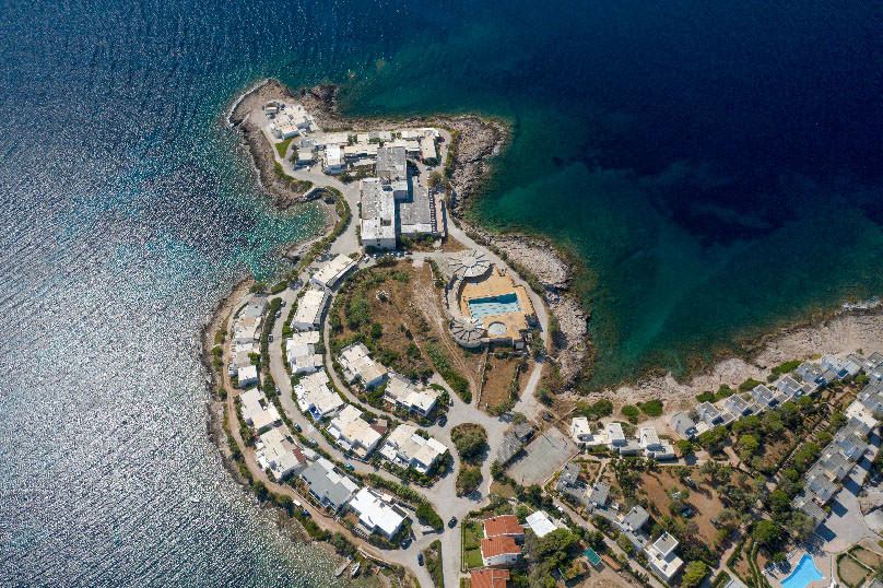 Aerial view of a seaside development on a rocky Attica peninsula